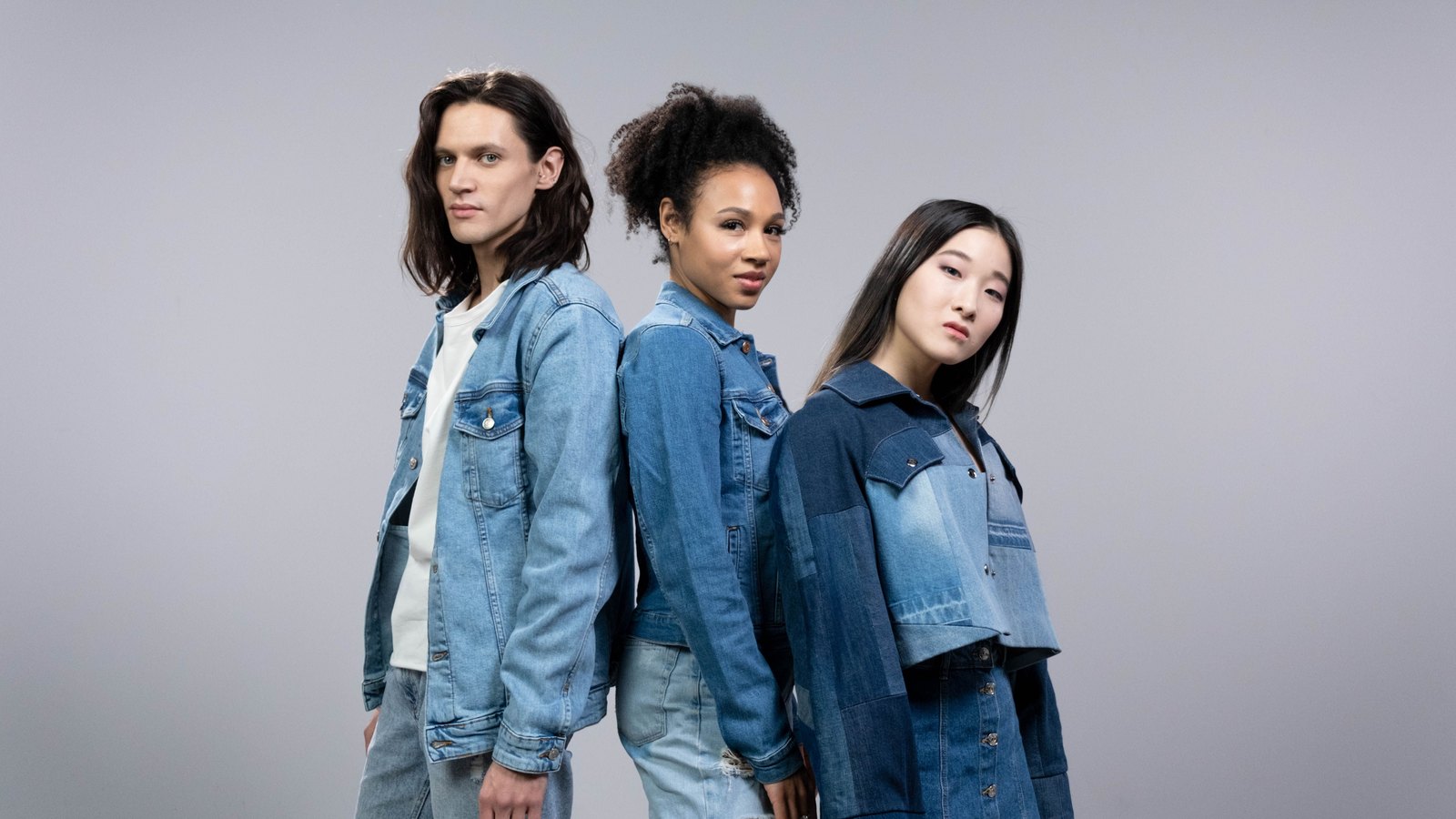 02 denim Trois personnes portant des vestes et pantalons en denim de délavages différents