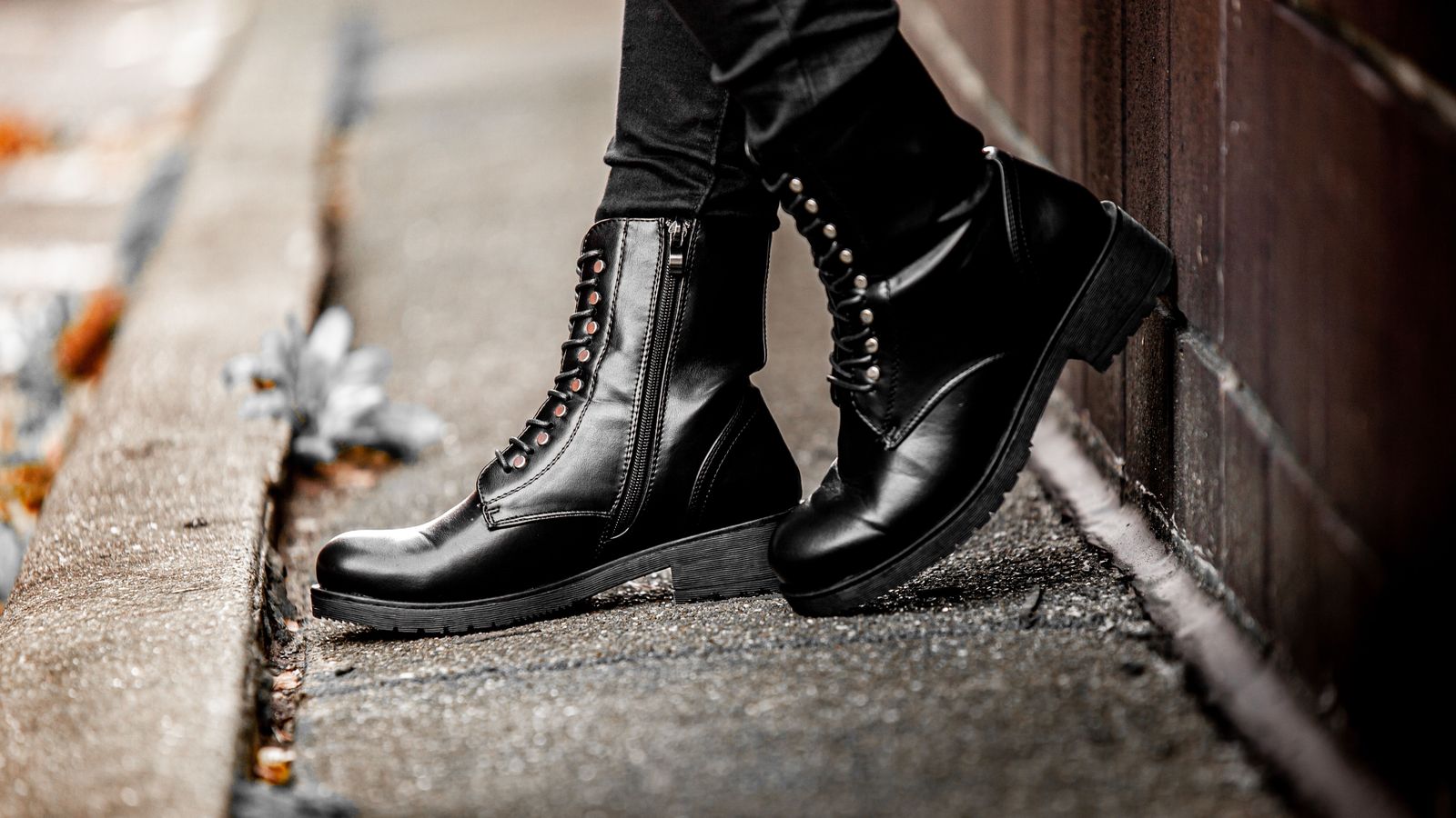 03 t2840 Bottines montantes noires à lacets portées sur un trottoir jonché de feuilles d'automne