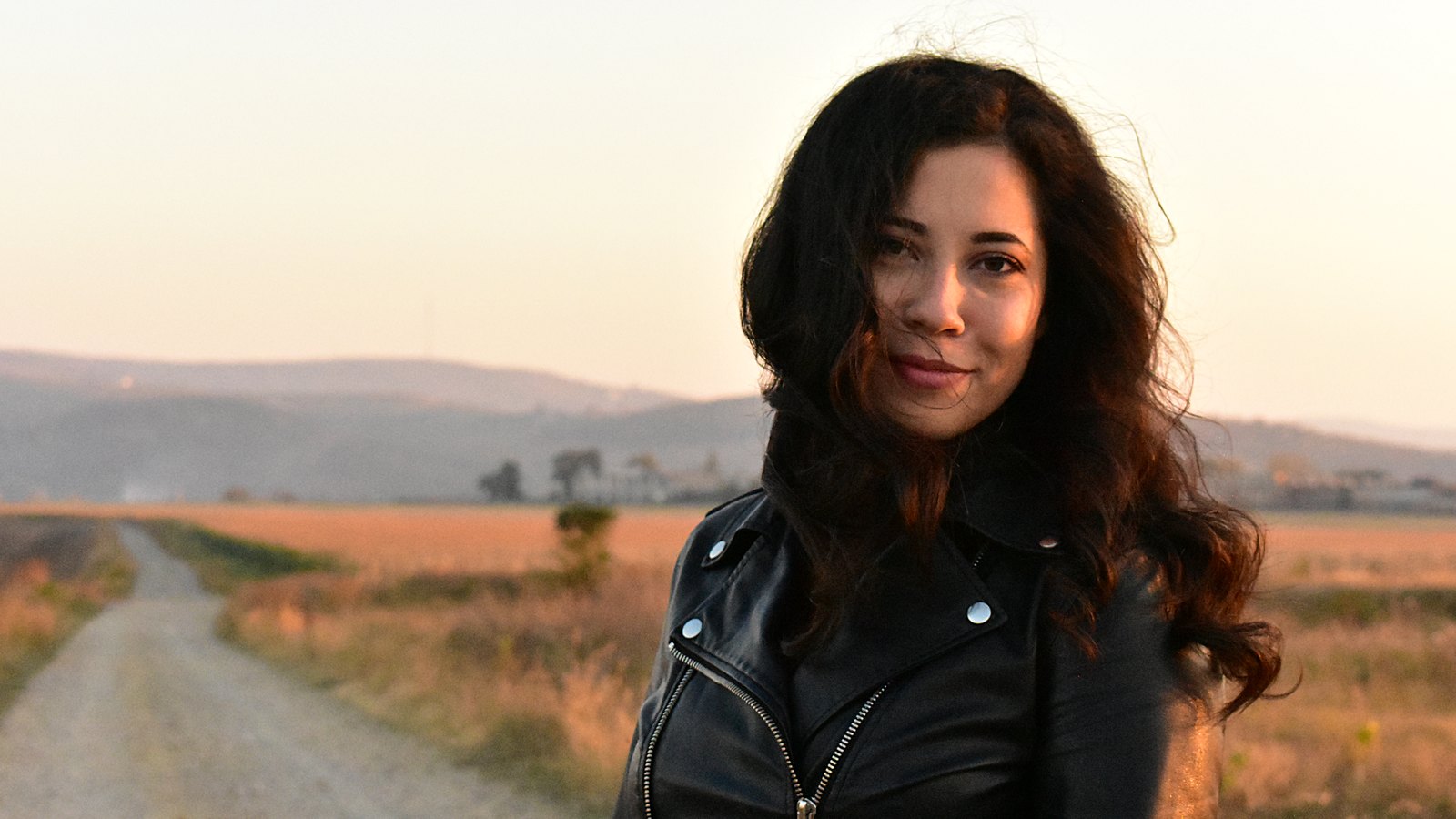 04 t2835 Femme en perfecto de cuir noir sur un chemin de campagne, lumière de fin de journée