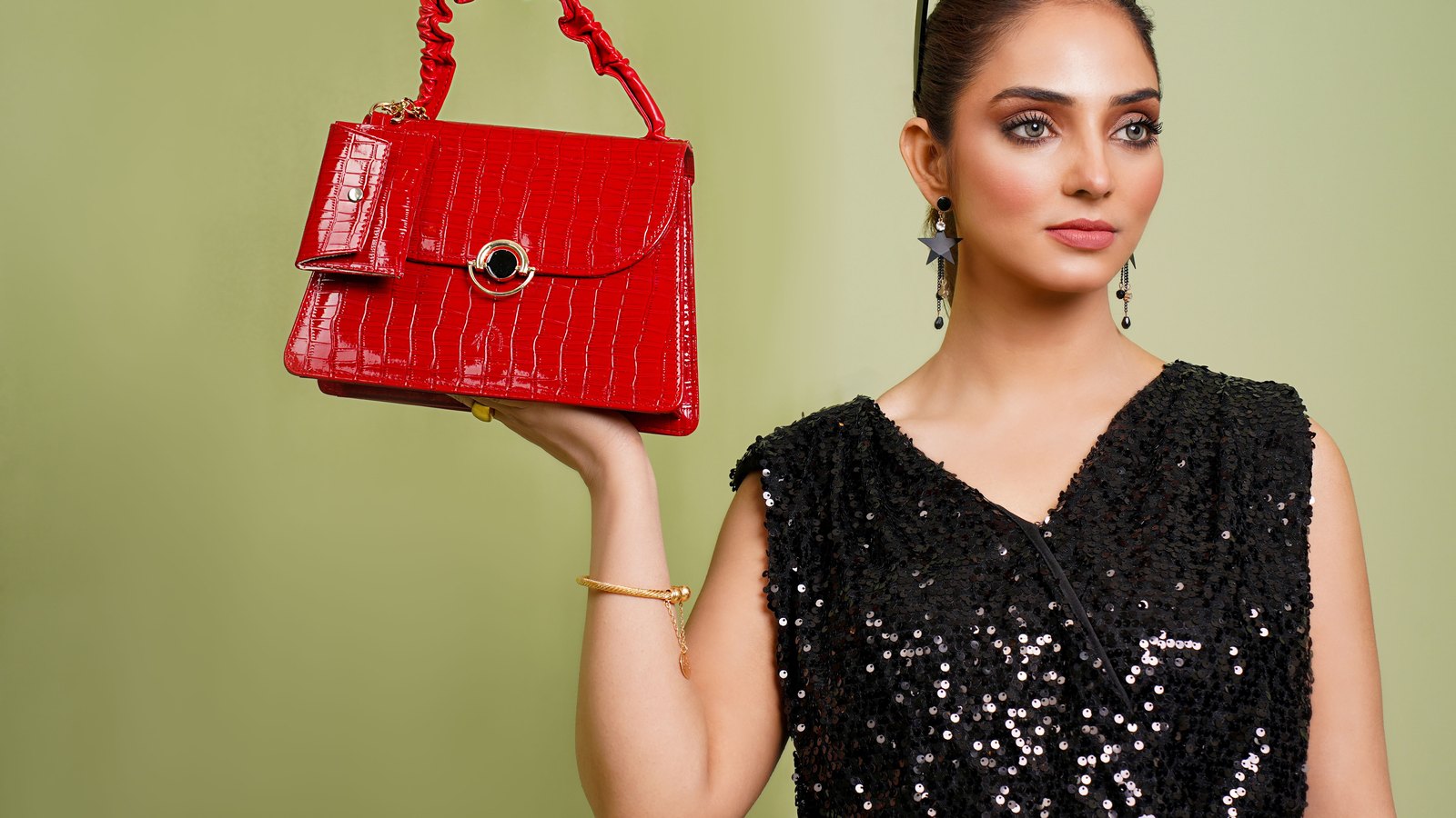 05 sacrouge Femme en robe noire tenant un sac à main rouge en cuir façon croco