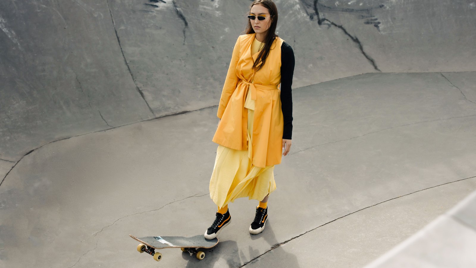 07 robepantalon Femme portant une robe jaune fluide par-dessus un pantalon