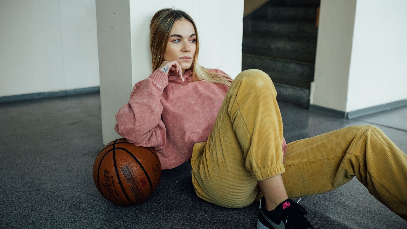 Femme assise portant un pantalon en velours côtelé kaki