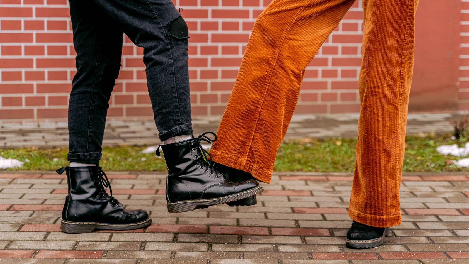 Deux personnes portant des pantalons en velours côtelé noir et orange